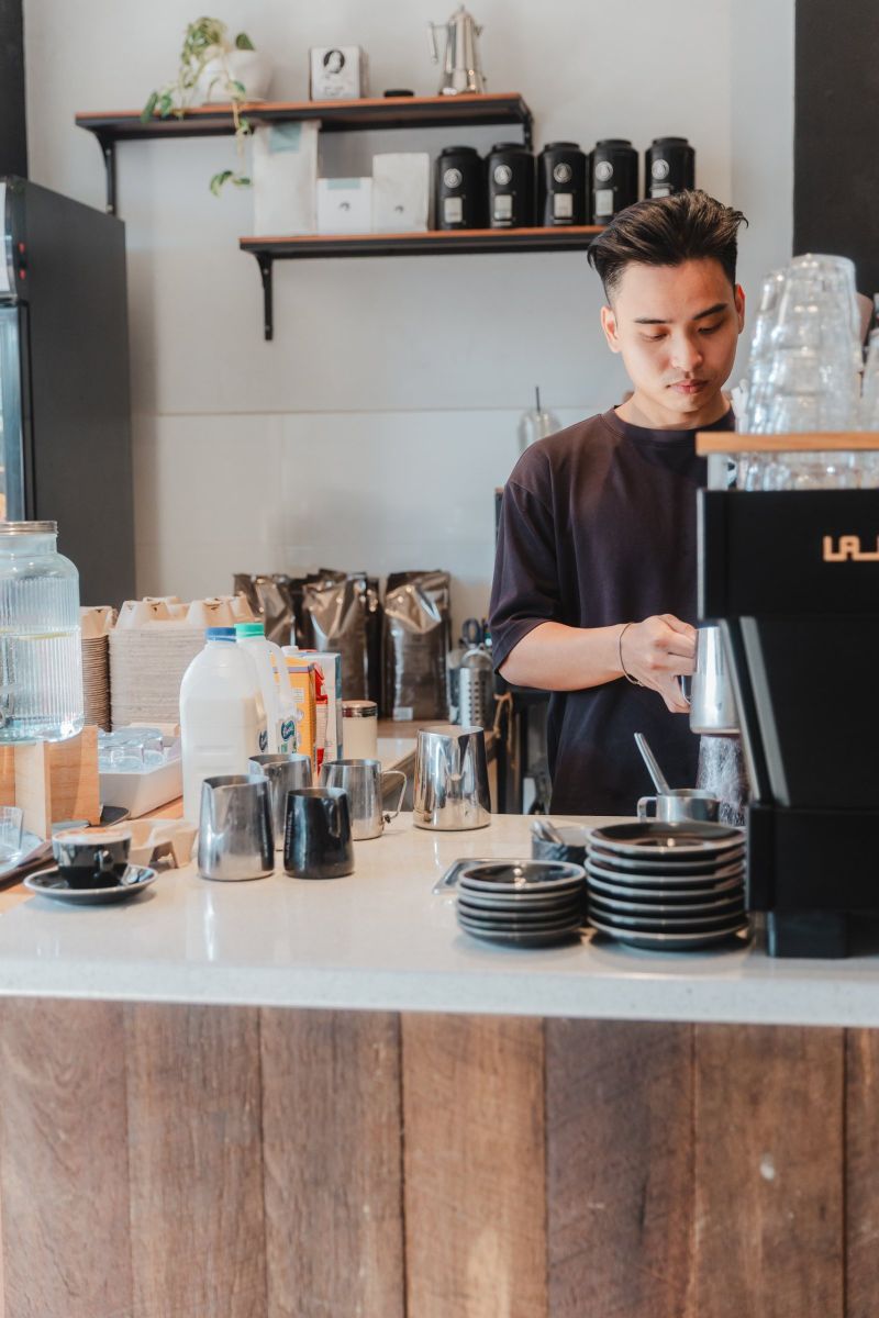 Barista steaming milk behind the Dossii counter