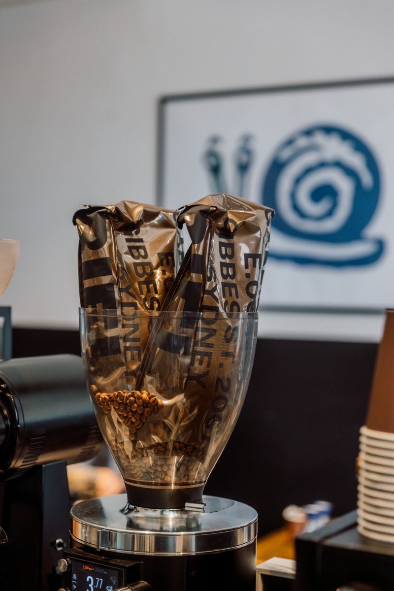 Gabriel Coffee beans in the grinder with the Dossii logo behind