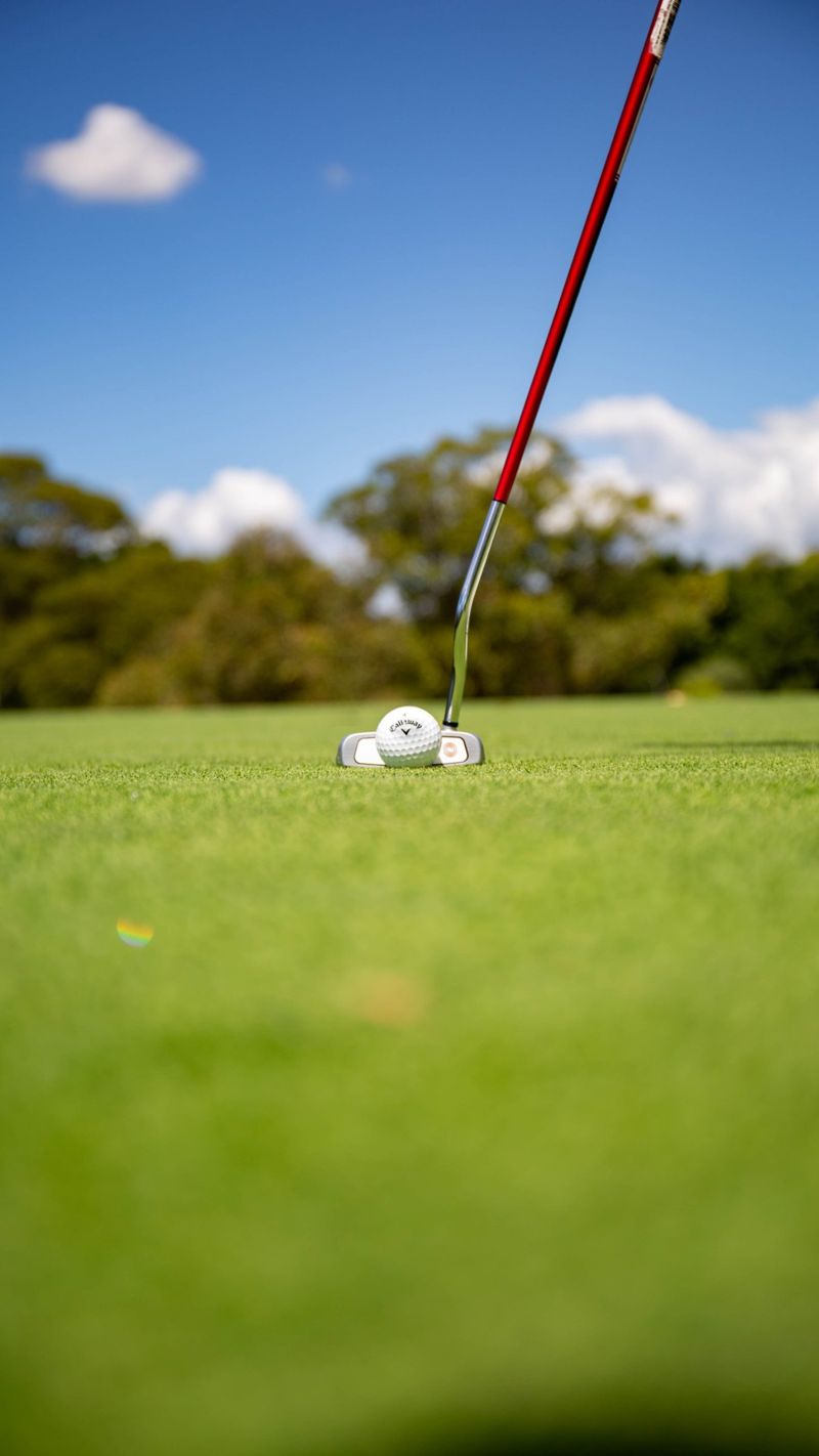 Low angle of a putter lined up behind a Callaway ball