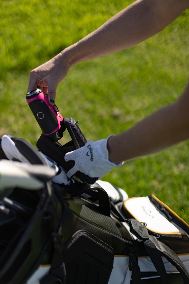 Pink rangefinder coming out of a Callaway golf bag